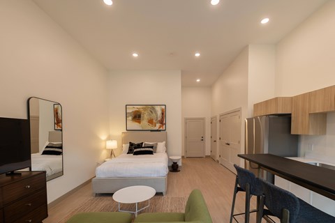 A bedroom with a bed, a chair, and a television.