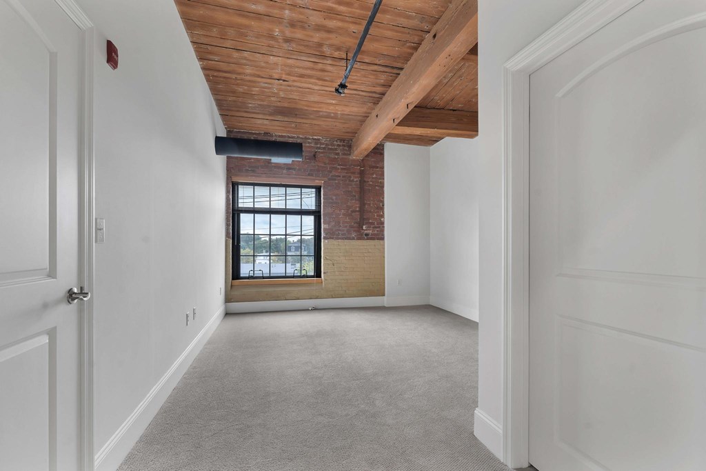 A room with a wooden ceiling and a window.