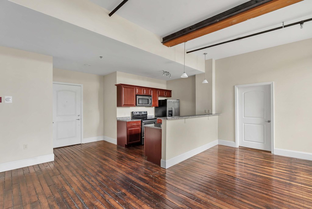 A kitchen with wood floors and white walls.