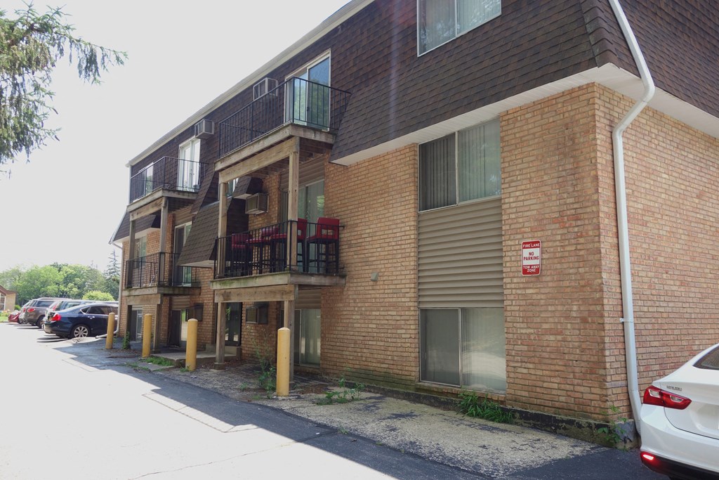 a brick apartment building with cars parked outside