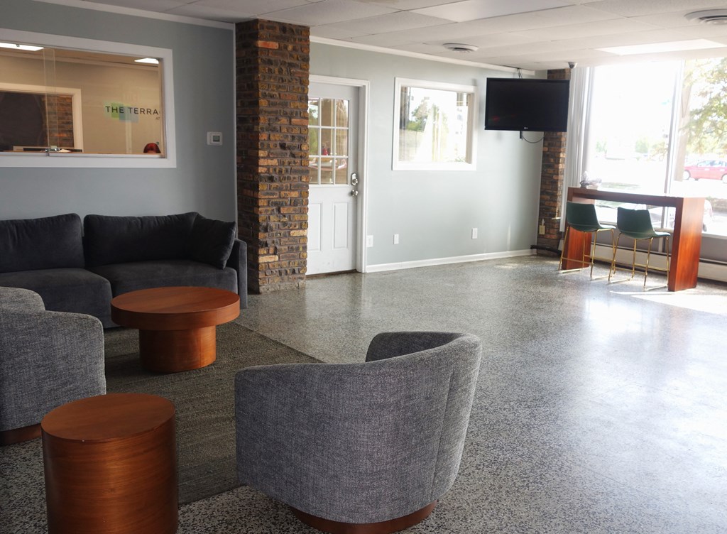 an empty living room with couches and chairs and a bar