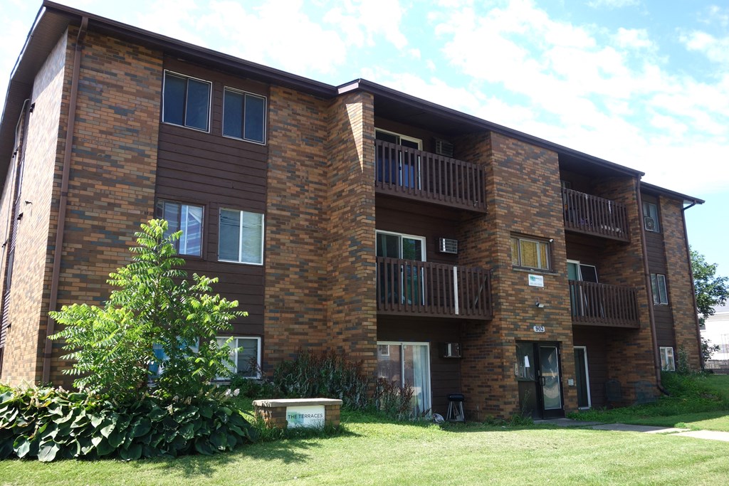 an apartment building with brown brick and balconies
