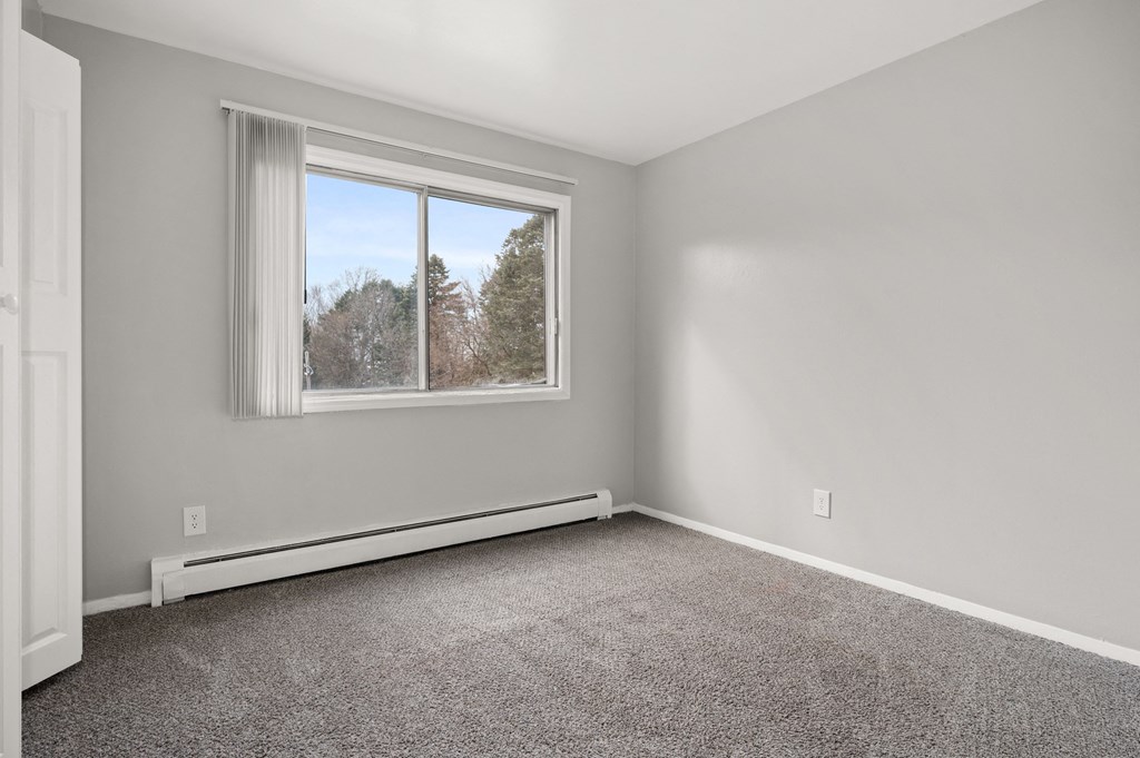 an empty room with carpet and a window