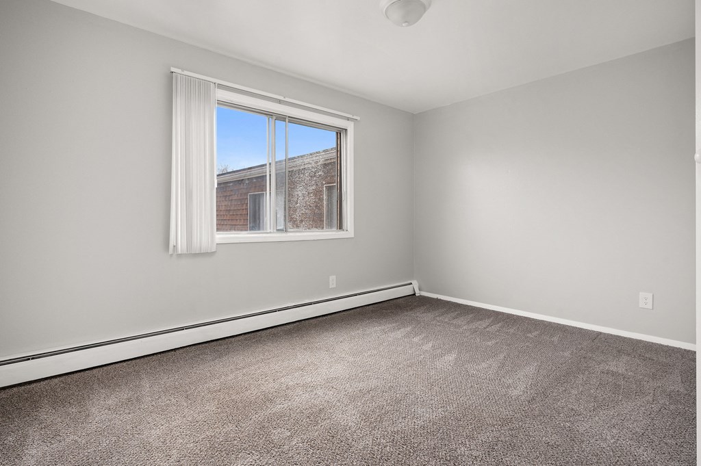 an empty room with carpet and a window