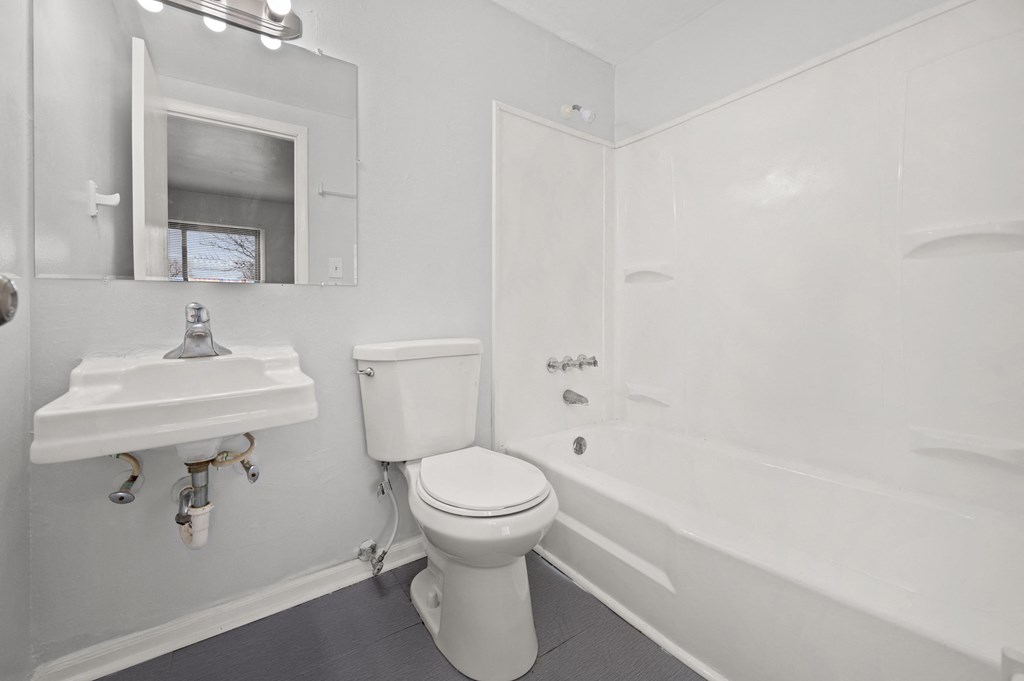 a bathroom with a toilet and a sink and a bath tub