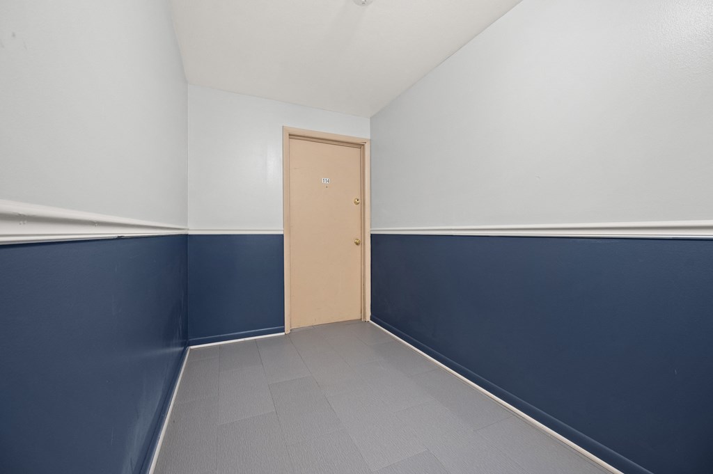 an empty room with blue and white walls and a door