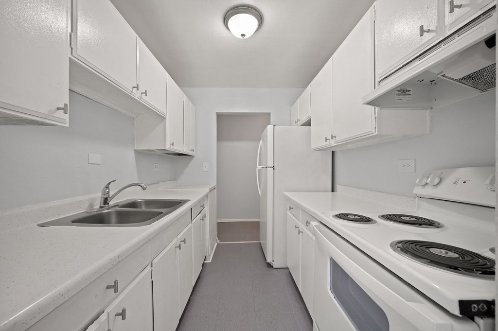 a kitchen with white appliances and white cabinets and a sink