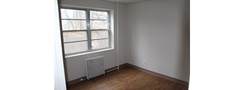 an empty room with a radiator and a large window