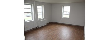 an empty room with three windows and a radiator