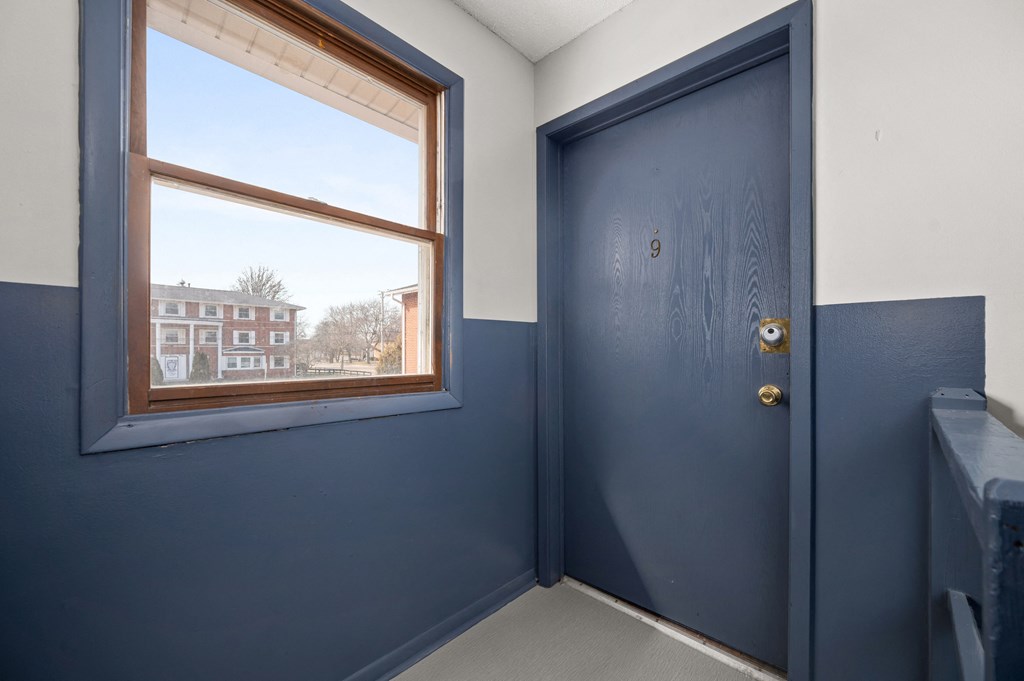 a blue door in a room with a window