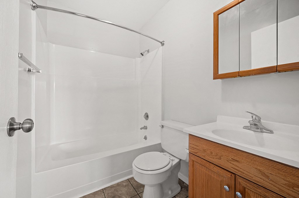 an empty bathroom with a shower toilet and sink