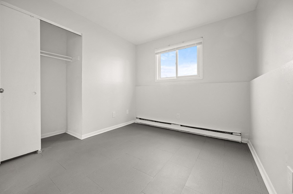 an empty room with white walls and a window