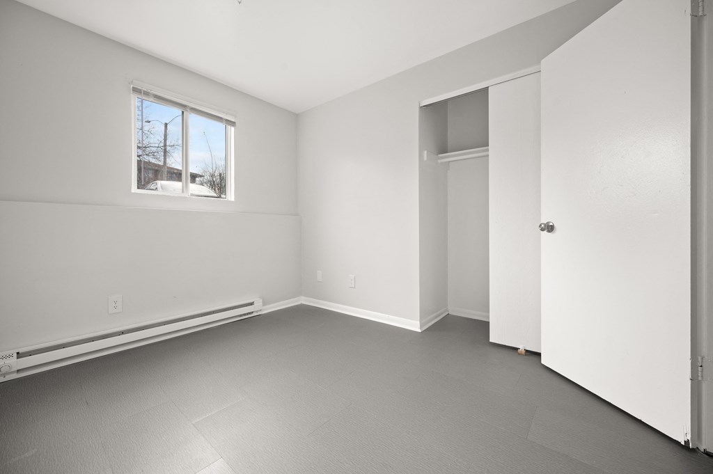 an empty room with white walls and a window