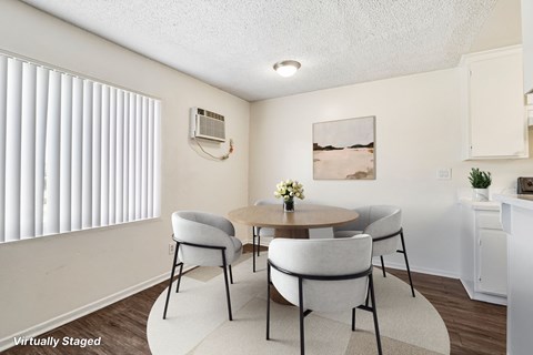 A dining room nicely lit by a large window.