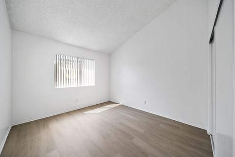 A room with a window and wooden flooring.