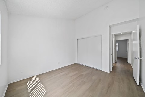 A room with a white wall and a striped rug on the floor.