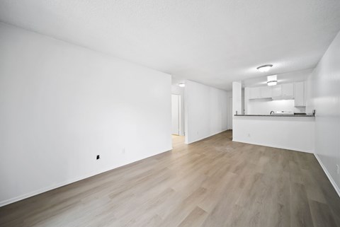 A room with wooden flooring and white walls.