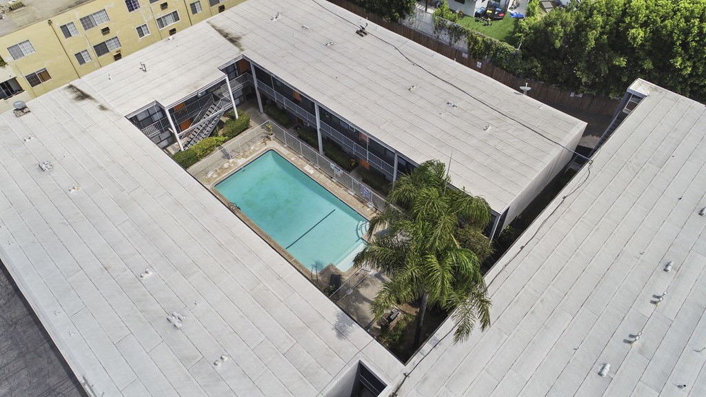 A rooftop with a pool and a fence.