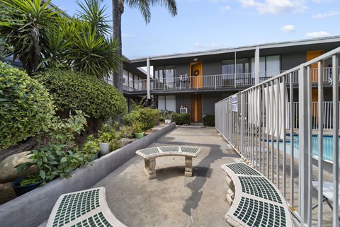 A patio area with a table and chairs and a pool.