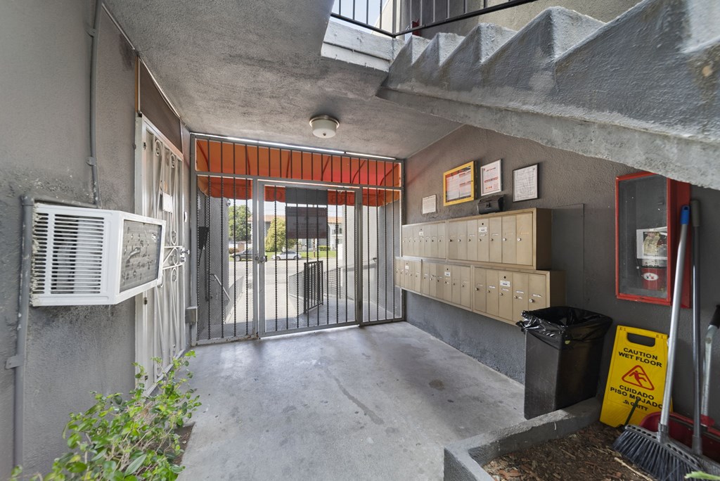 A concrete room with a red awning and a metal gate.