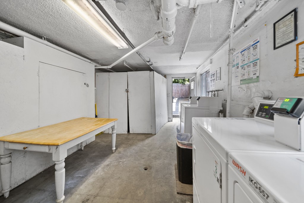 A white industrial room with a table and a white machine.