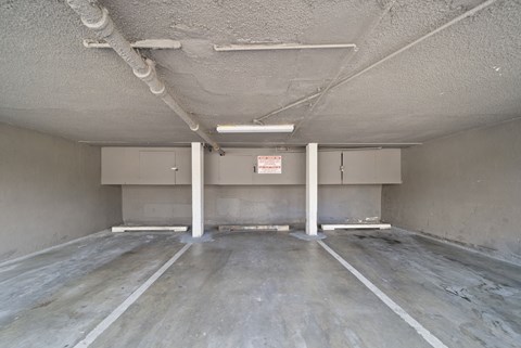A spacious, unfinished room with concrete floors and walls, and exposed pipes on the ceiling.