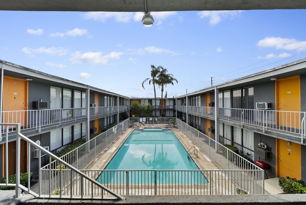 A pool in a courtyard surrounded by buildings.