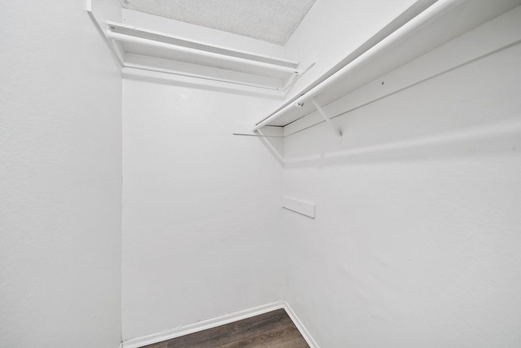 A white wall with a brown floor and a white ceiling.
