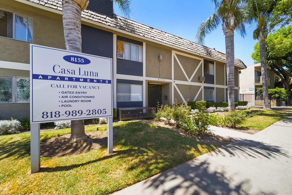 A sign for Casa Luna Apartments is displayed in front of a building.