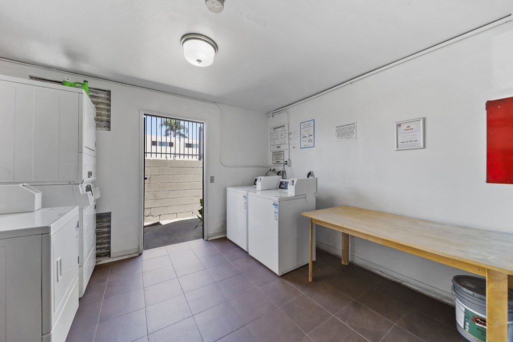 A kitchen area with a washing machine and a dining table.