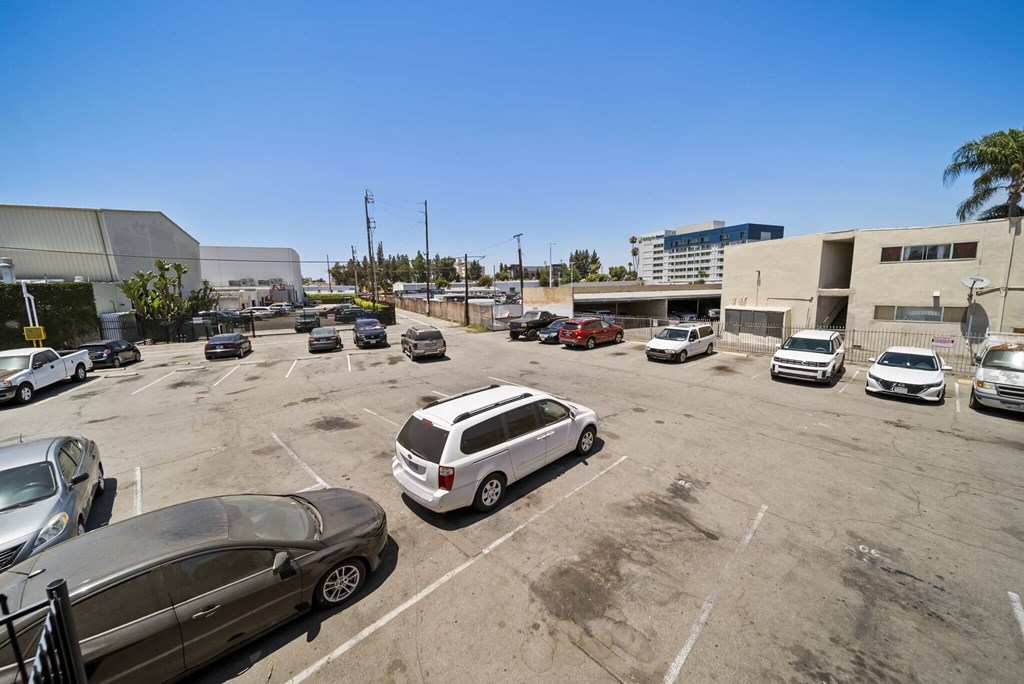 A parking lot with several cars and a building in the background.