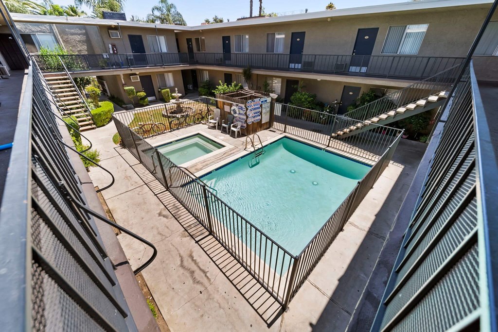 A small pool in a courtyard surrounded by a fence.