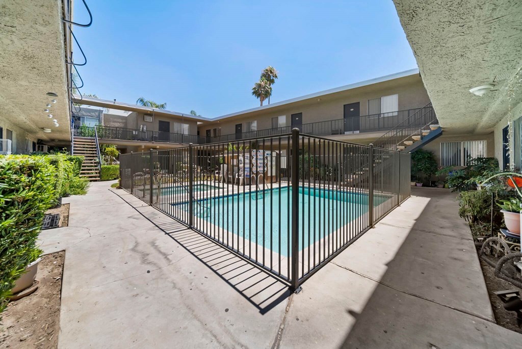 A black iron fence surrounds a small pool.