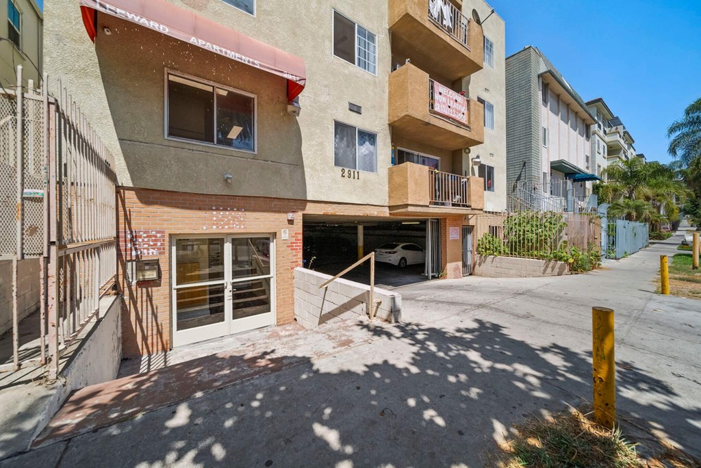 A building with a red awning and a white car parked in the garage.