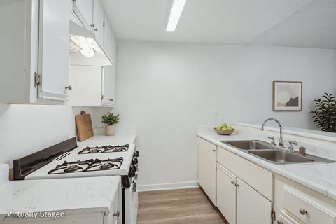 A kitchen with a stove top oven and a sink.