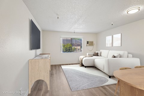 A living room with a white couch and a wooden cabinet.