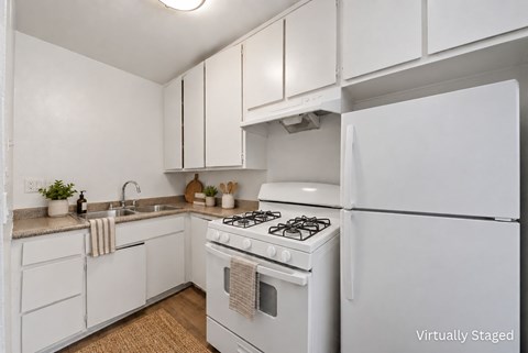A white kitchen with a stove and refrigerator.