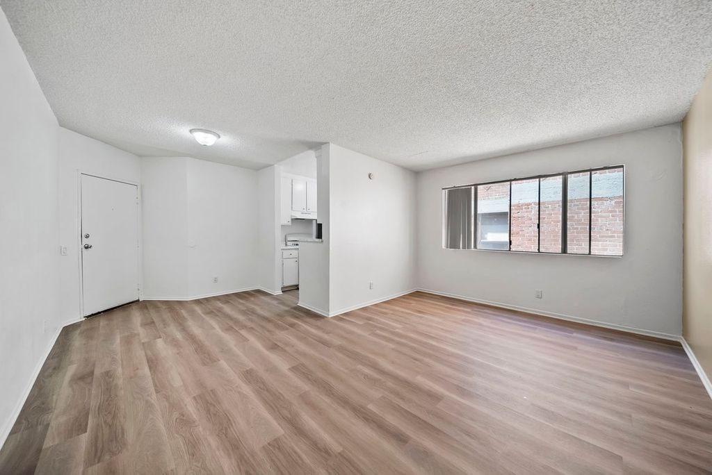 A room with wooden flooring and white walls.