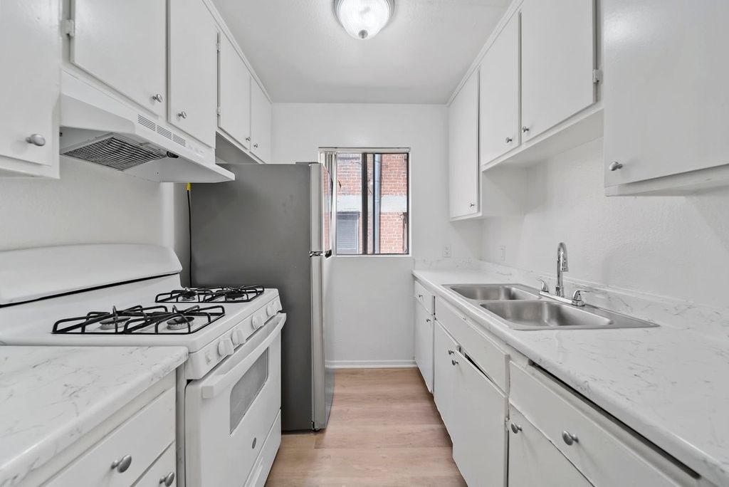 A kitchen with white appliances and cabinets.