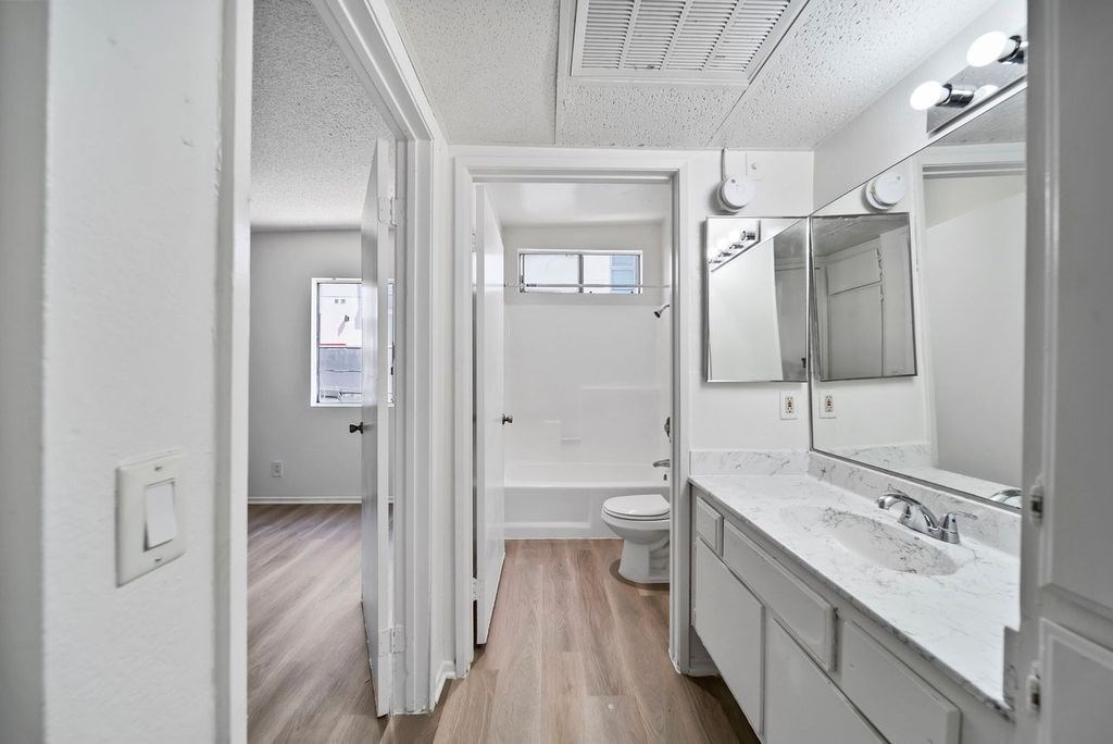 A white bathroom with a toilet, sink, and mirror.