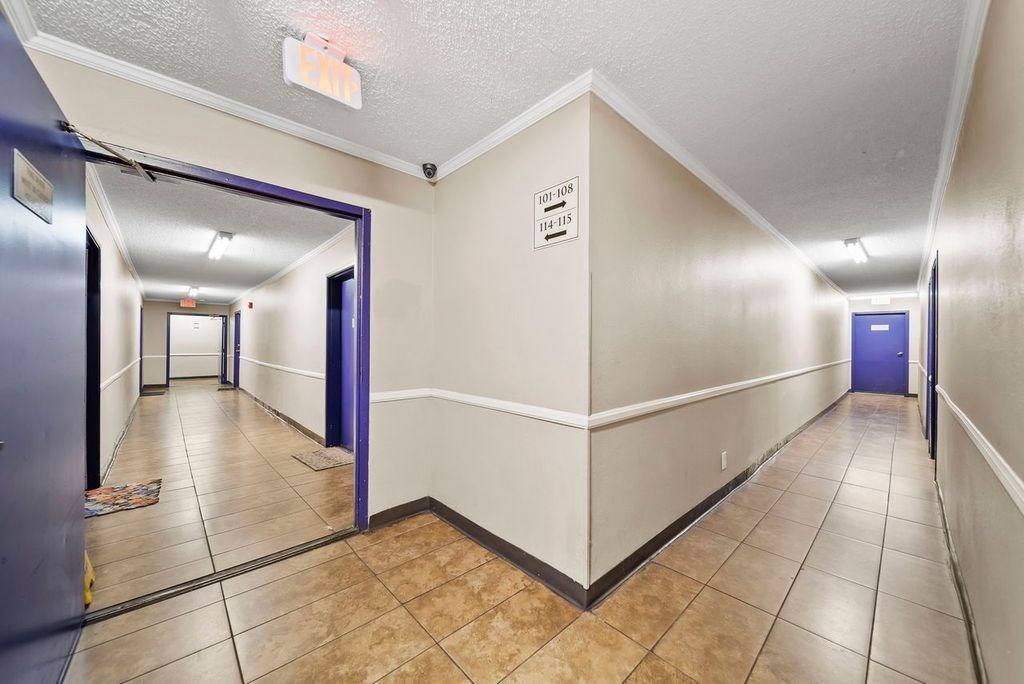 A hallway with a sign that says "EXIT ONLY" on the wall.