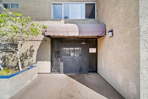A building with the number 1008 on it has a closed gate.