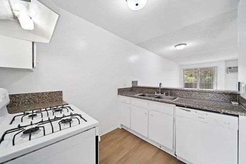 A white kitchen with a black stove top.