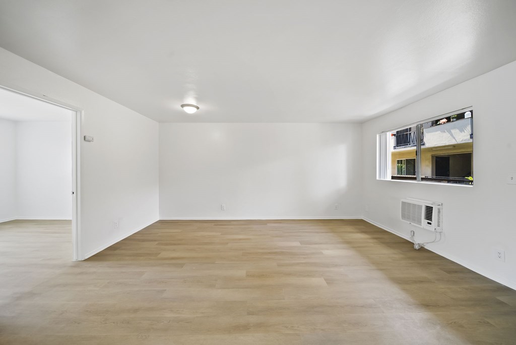 A room with a white ceiling and a window with a view of a building.