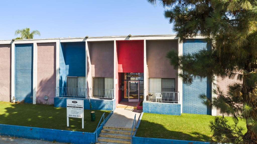 A building with a blue, pink and red exterior.