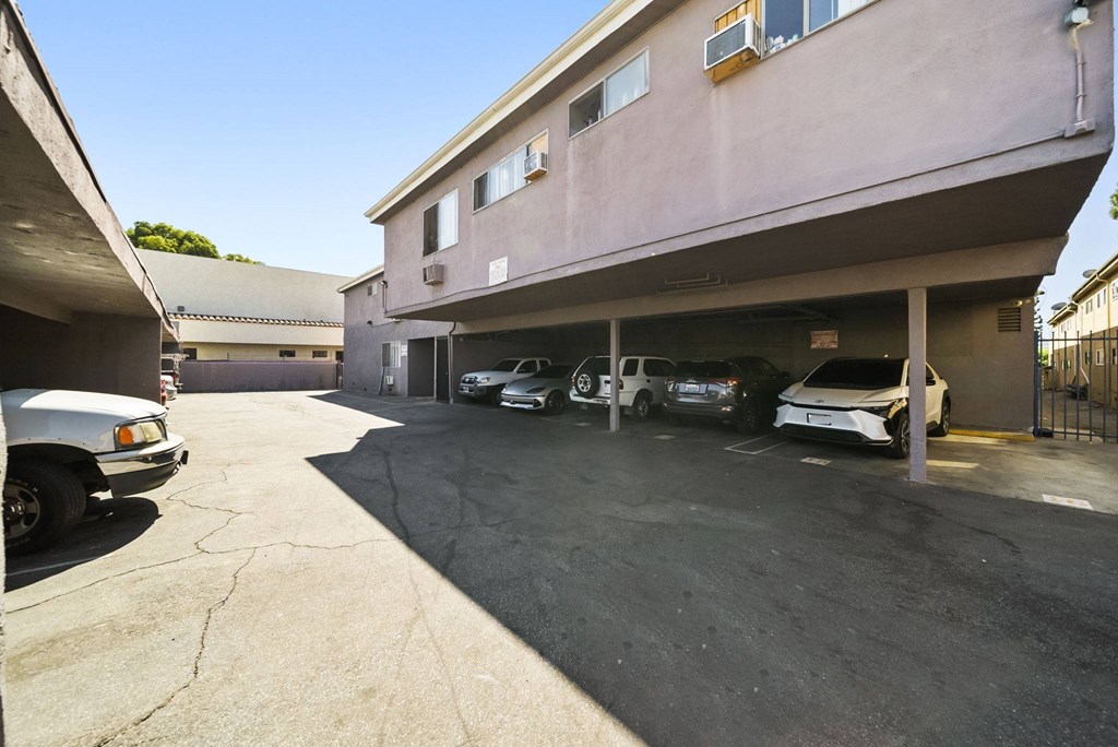A parking lot with a building and cars.