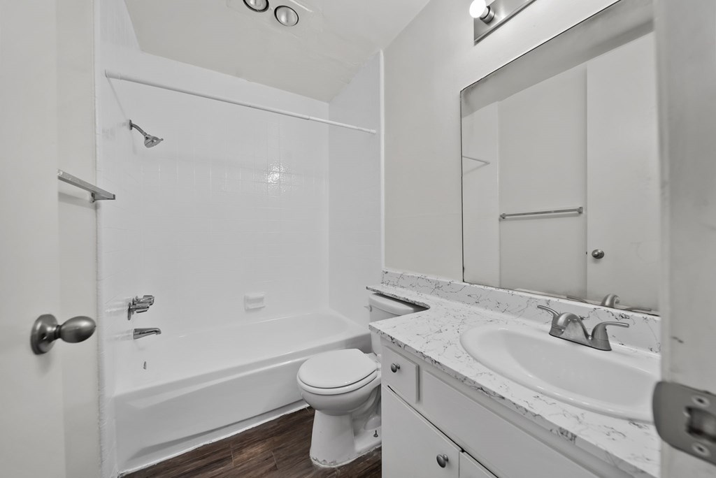 A white bathroom with a toilet, sink, and bathtub.