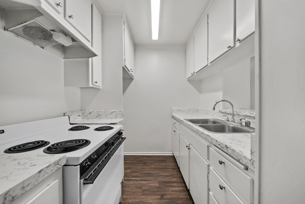 A kitchen with white appliances and cabinets.