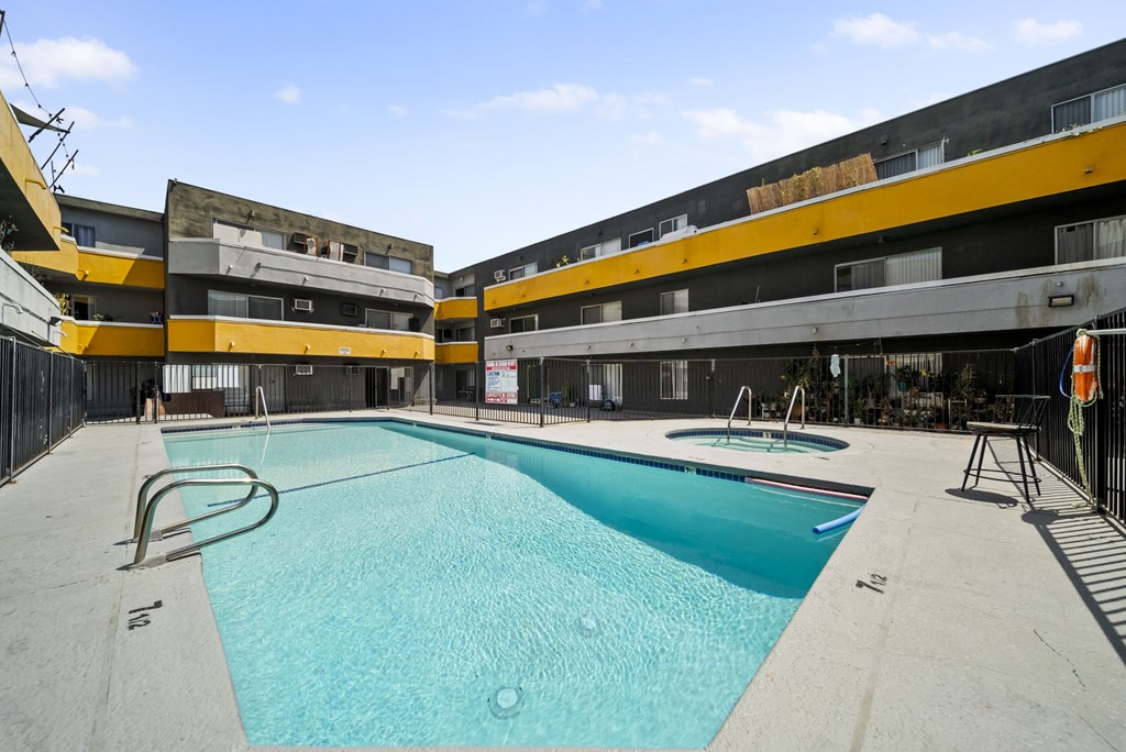 A swimming pool in a courtyard surrounded by buildings.