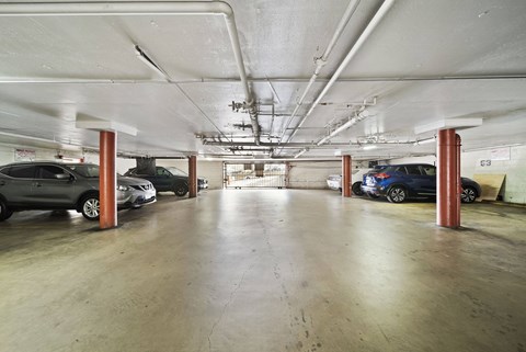 A parking garage with several cars parked in it.
